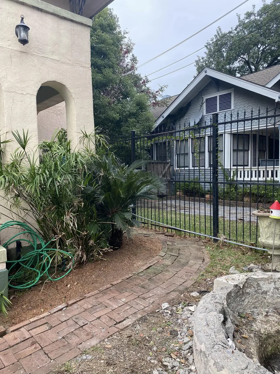 Yard cleared after tree removal beside an iron fence